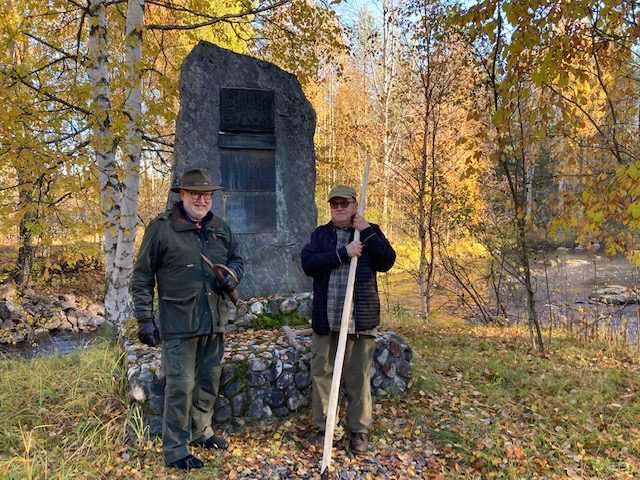 Juhani Hakkarainen ja Kaleva Hämäläinen kertoivat syyskuussa 2021 koululaisten metsäpäivässä uiton historiaa Kaavin alakoululaisille. Kuva otettu Vaikkojoen Rakkinekoskella sijaitsevalla uittomuistomerkillä.  